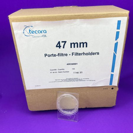 Boxed coffee equipment labeled '47 mm Porte-filtre - Filterholders' with Tecora branding on a purple background, plus a clear plastic cap in front.